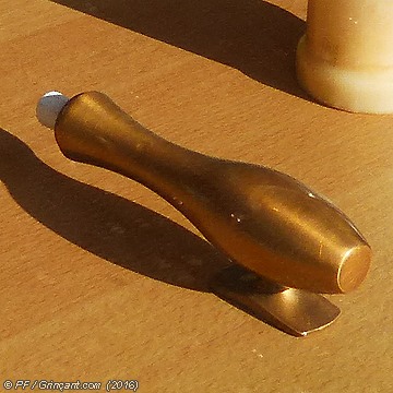 Objet doré posé sur une table, derrière une vitrine
