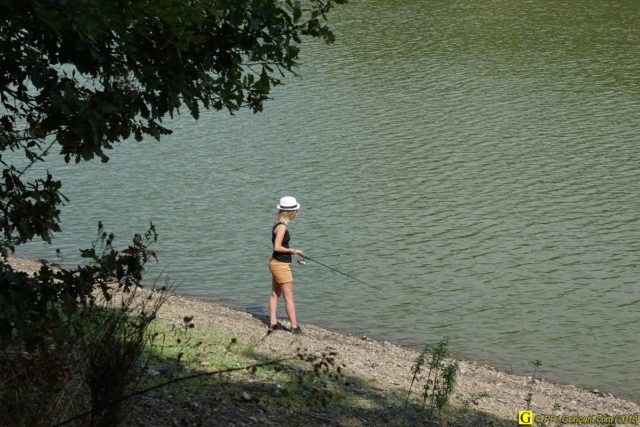 Pêcheuse au chapeau blanc, en bord de lac